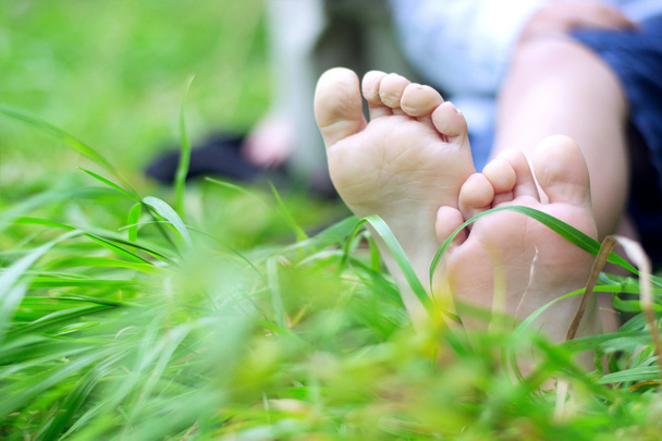 Little boy's feet on grass - Foto, afbeelding