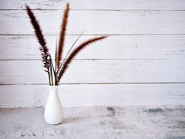 Purple Fountain Grass flowers in vase on table vintage background and desert rose ,copy space for letter white vase old wall for wallpaper or text message writing still life black and white gray color - Foto, imagen