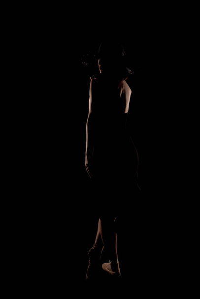 Chica misteriosa en el estudio posando en vestido negro y sombrero negro - Foto, Imagen