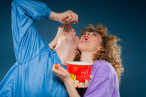 Two amazing and beautiufl friends are having fun with the popcorn - 写真・画像