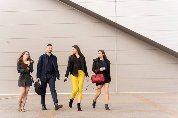 Group of young business people are talking about their business plans and ideas and walking all together in front of the company - Фото, изображение