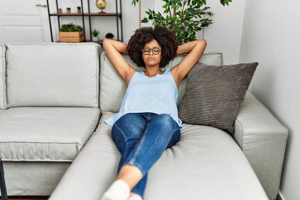 Young african american woman relaxed with hand on head at home - Zdjęcie, obraz