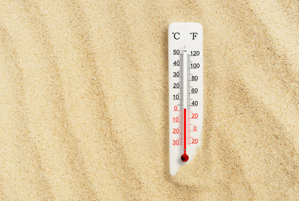 Une chaude journée d'été. Thermomètre à écailles Celsius et fahrenheit dans le sable. Température ambiante plus 2 degrés - Photo, image