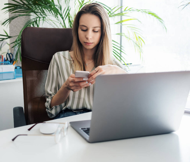 Fiatal nő dolgozik egy számítógépen az irodájában - Fotó, kép