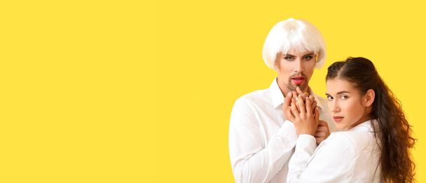 Portret van jong transgender koppel op gele achtergrond met ruimte voor tekst - Foto, afbeelding