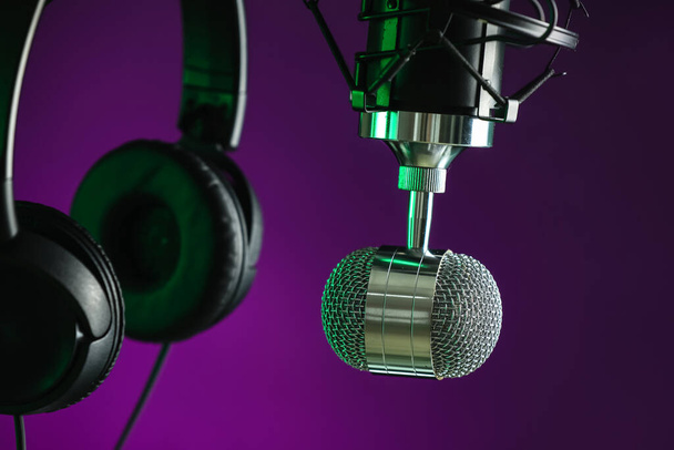 Modern microphone and headphones on dark color background, closeup - Fotó, kép