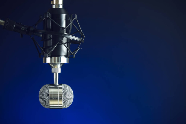 Stand with microphone on blue background, closeup - Fotó, kép