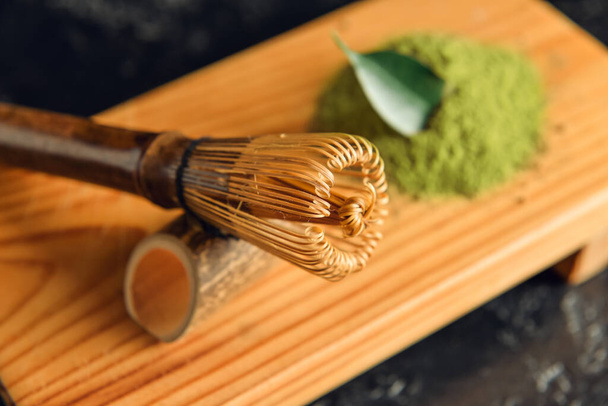 Placa de madeira com chasen de bambu e chá de matcha em pó, close-up - Foto, Imagem