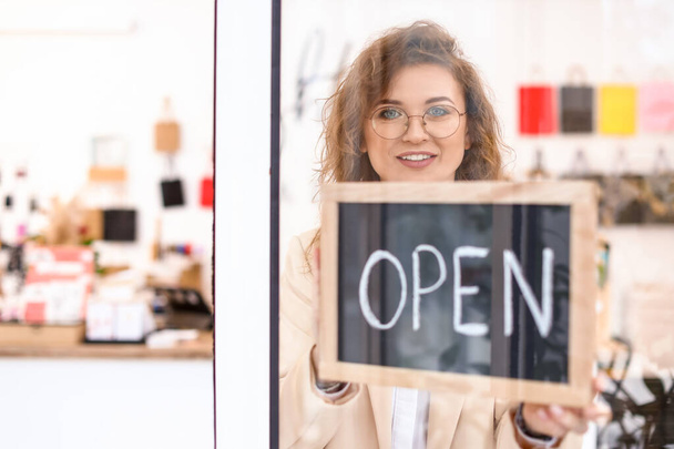 Young female business owner opening her shop - Foto, Bild