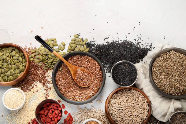 Variety of edible seeds on light background. Cereal and grains. Healthy food concept. Top view, flat lay, copy space - Φωτογραφία, εικόνα