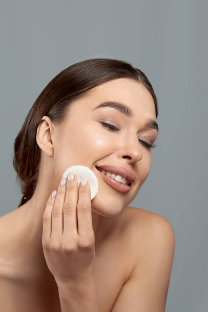 Woman Cleaning Face With White Pad. Beautiful Girl Removing Makeup White Cosmetic Cotton Pad. Happy Smiling Female Taking Off Makeup From Facial Skin With Cosmetic Pad. Face Skin Care.  - Fotografie, Obrázek