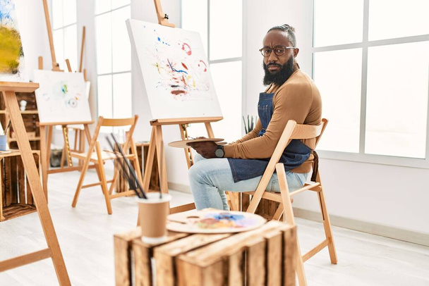 アフリカ系アメリカ人のアーティストの男は、アートスタジオでキャンバスに絵を描く思考態度と冷静に表現自信を持って見える  - 写真・画像