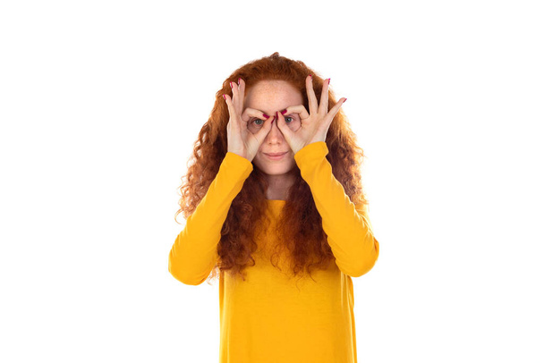 Hezká zrzka žena v oranžovém tričku, stojící nad bílým pozadím, ukazující na oko a pozorující tvé gesto, podezřívavý výraz  - Fotografie, Obrázek