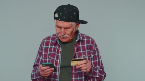 Mies käyttää matkapuhelin ja muovi luottokortti, selailu sanoa wow kyllä selville suuri iso voitto - Materiaali, video