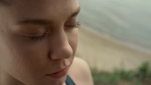 Closeup girl face meditating on beach. Portrait of focused woman doing yoga - Materiał filmowy, wideo