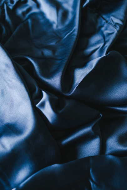 luxurious navy blue silk or satin fabric close-up for bedding or clothes, with soft wrinkle and light shining on it  - Zdjęcie, obraz