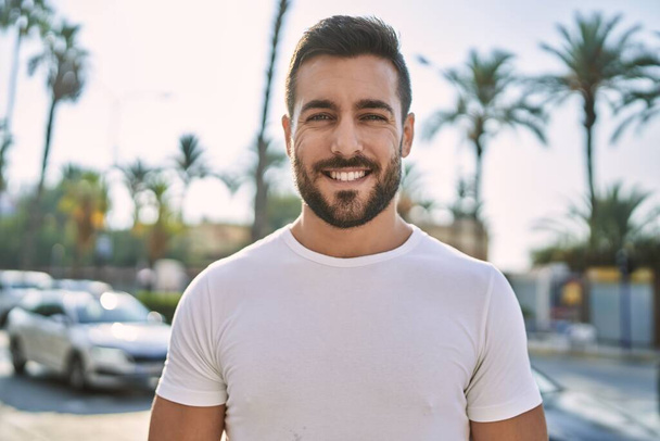 Junger hispanischer Mann lächelt selbstbewusst auf der Straße - Foto, Bild