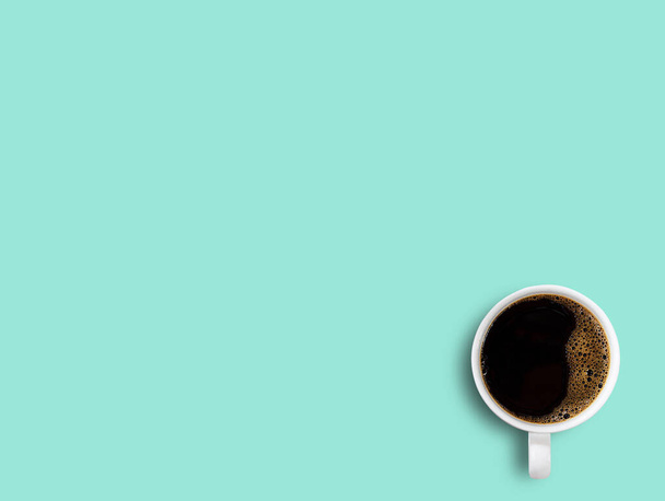 Cup of coffee on green table background. Top view with copy space for your design. - Foto, imagen