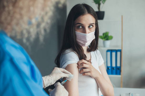 View from doctors back hands holding syringe and cleaning skin on upper arm before vaccination. Antivirus concept. Medicine concept. Virus protection. Medical - Foto, Imagem
