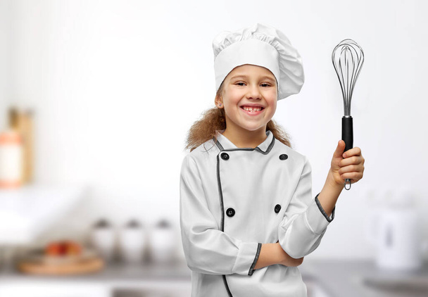 smiling little girl in chefs toque with whisk - Φωτογραφία, εικόνα