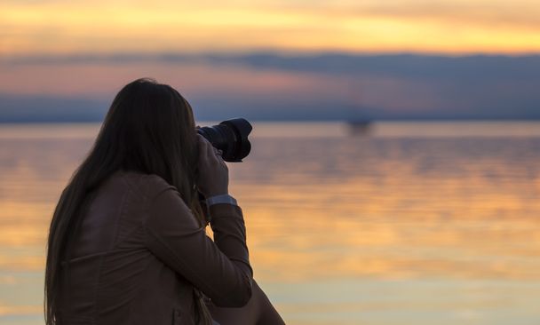 girl photographing sunset at lake in autumn - Fotografie, Obrázek
