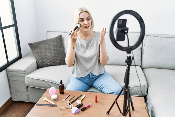 Young caucasian woman having video call using brush at home - Photo, Image