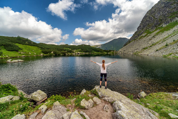 Ragazza turista in piedi e guardando sulla bella natura con lago e montagne estive in Tatra occidentale in Slovacchia. Tema escursionistico. - Foto, immagini