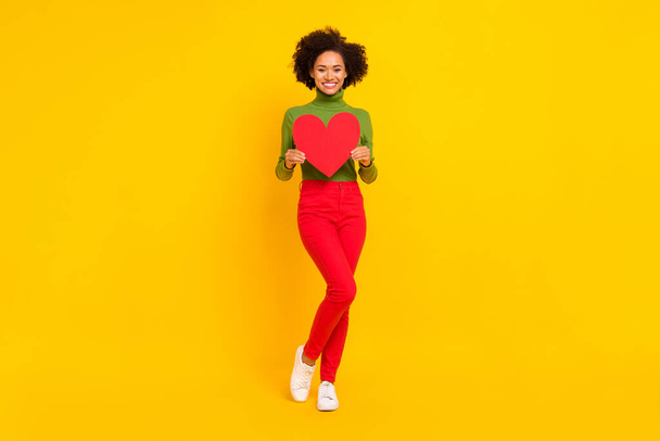 Full length photo of young cheerful girl hold heart shape romance feelings girlfriend isolated over yellow color background - Fotoğraf, Görsel