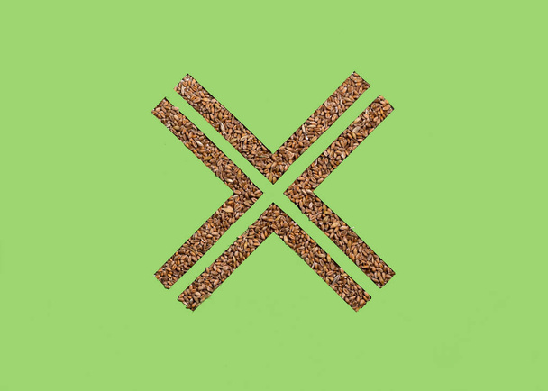 Wheat grains in a cross shape hole cut into paper. Celiac Disease Awareness Month Concept. - Zdjęcie, obraz