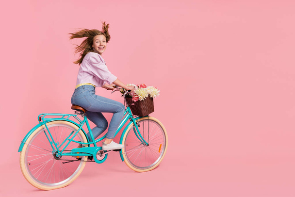 Photo of funky courier lady person drive bike wind blow hair wear casual outfit isolated pink color background - Fotografie, Obrázek