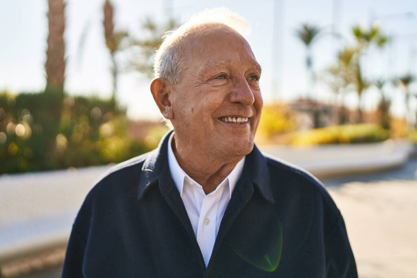 Senior man smiling confident standing at park - Foto, afbeelding