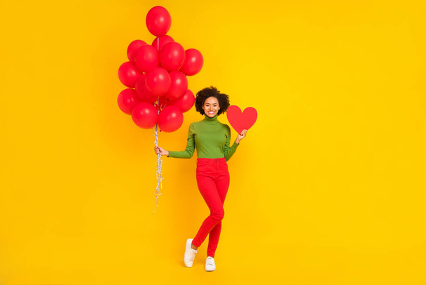 Full body photo of young cheerful girl hold many helium balloons present isolated over yellow color background - Φωτογραφία, εικόνα