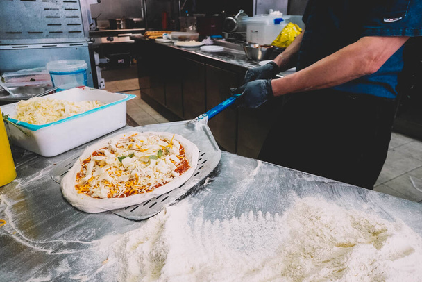 A chef specialized in Neapolitan pizzas preparing the dough - Foto, Imagem