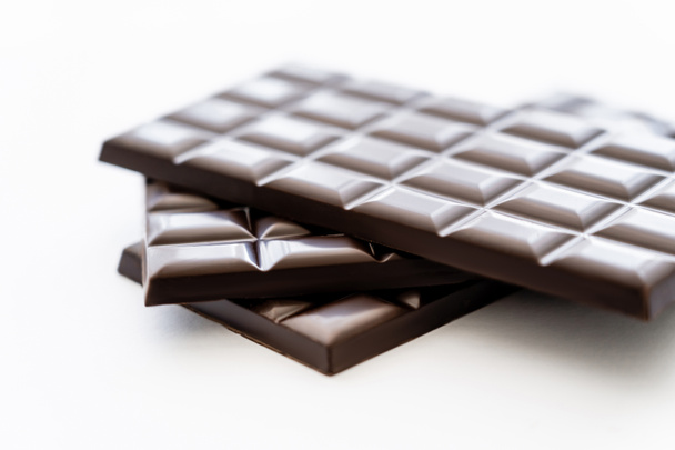 Close up view of bars of dark chocolate on white background  - Photo, Image