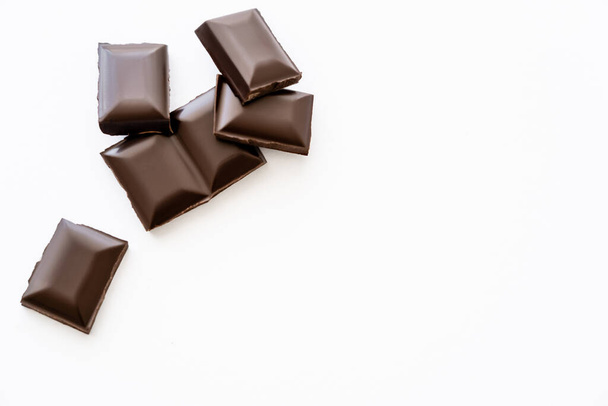 Ansicht von Schokoladenstücken auf weißem Hintergrund mit Kopierraum - Foto, Bild