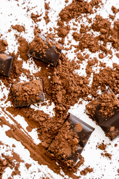 Top view of natural cocoa powder on chocolate on white background  - Фото, зображення