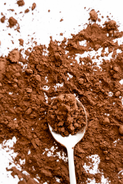 Top view of natural cocoa powder on spoon on white background  - Valokuva, kuva