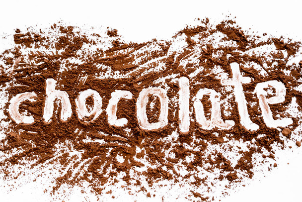 Top view of chocolate lettering in dry cocoa on white background  - Photo, Image