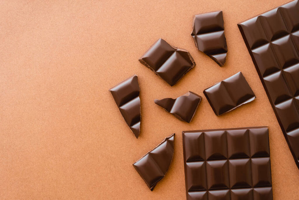 Top view of dark chocolate on brown background with copy space - Fotó, kép