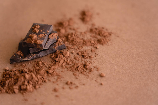 Close up view of dark chocolate and cocoa powder on brown background with copy space - Fotoğraf, Görsel