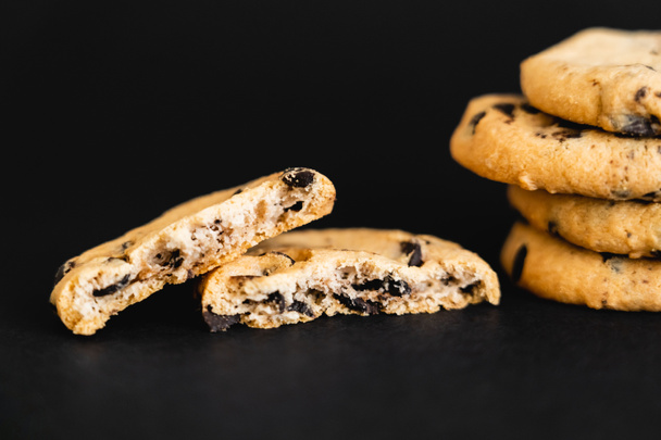 Close up view of tasty cookies with chocolate chips on black background - Fotó, kép