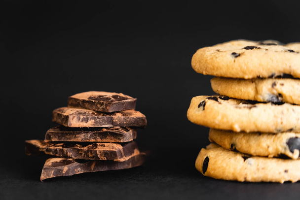 Közelkép a darab csokoládé kakaóval közel cookie-k fekete háttér - Fotó, kép