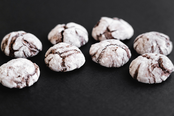 Close up view of biscuits with powdered sugar on black surface  - Foto, Imagem