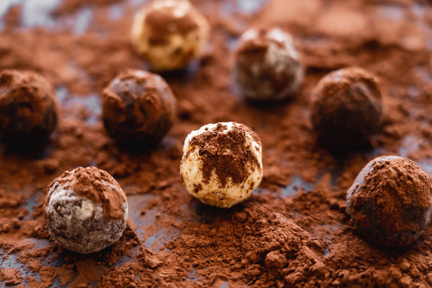 Vista da vicino di gustose caramelle con cacao su sfondo nero  - Foto, immagini
