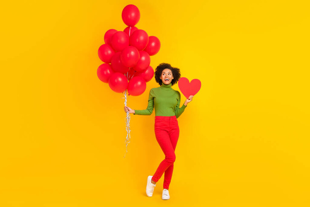 Full body photo of young excited girl dreamy hold many balloons birthday event isolated over yellow color background - Photo, Image