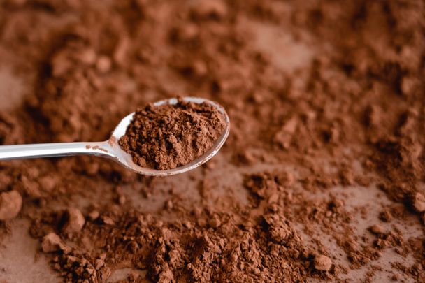 High angle view of cocoa in spoon and on brown background  - Foto, immagini