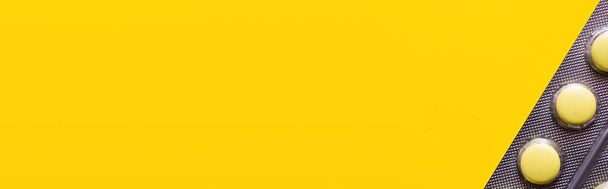 close-up van blisterverpakking met pillen geïsoleerd op geel, banner - Foto, afbeelding