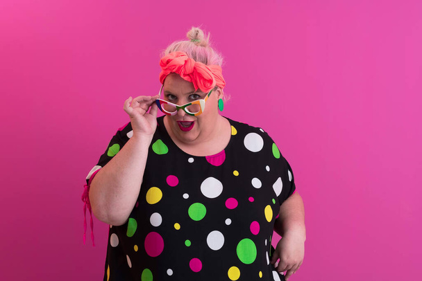 Happy Plus Size Woman Wearing Eyeglasses Smiling To Camera Standing Over Pink Background. Cheerful Millennial Female In Eyewear Posing In Studio. - Φωτογραφία, εικόνα