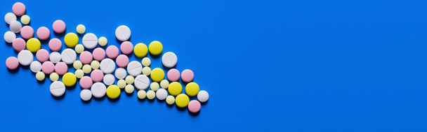vue plate de différentes pilules de forme ronde sur fond bleu, bannière - Photo, image