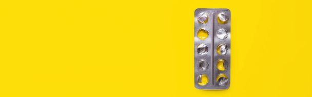 top view of used blister pack isolated on yellow, banner - 写真・画像